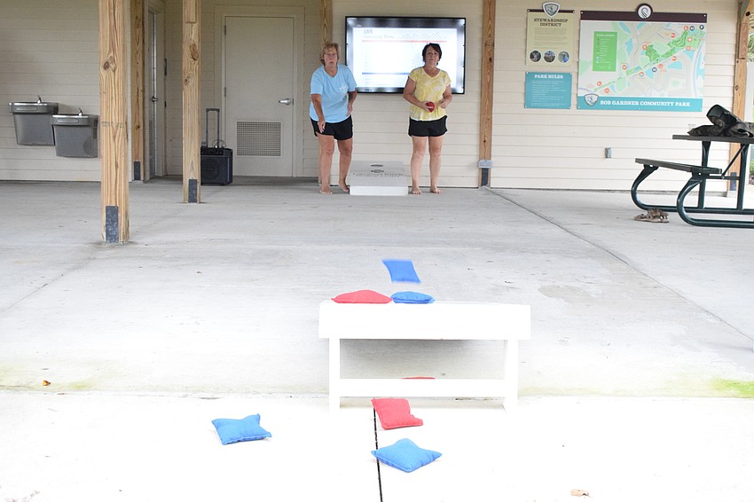 Lakewood Ranch's Kelly Harmon competes against Carolyn Ray in a game of cornhole. While some bags landed on the boards, others went a bit past the board.