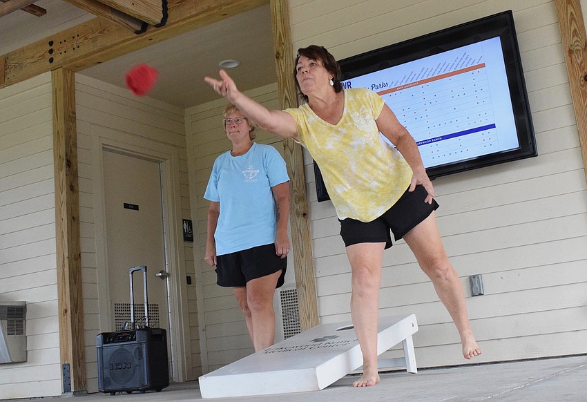 Lakewood Ranch's Kelly Harmon and Carolyn Ray have fun getting to know each other while playing cornhole.