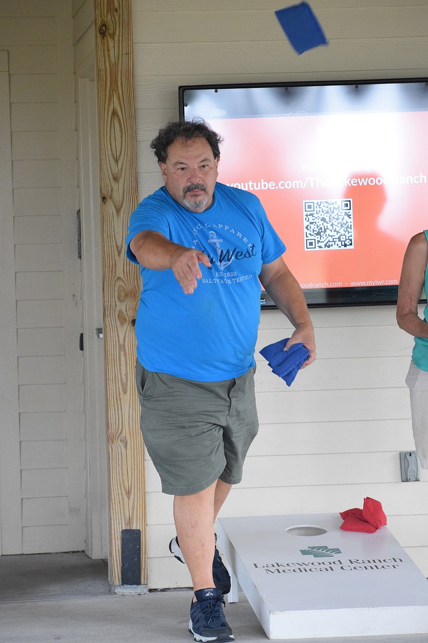 Lakewood Ranch's Marty Saia tries to sink his bag in the hole of the cornhole board.