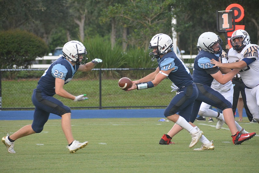 ODA senior Grady Paxton (23) gets a handoff from senior Connor Pope (17).