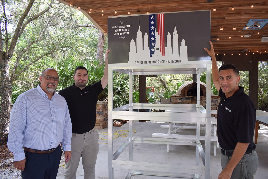 James Hugglestone II of Fawley Bryant and Brandon Gundrum and Angel Ortiz of Willis Smith Construction stand next to the partially built cube.