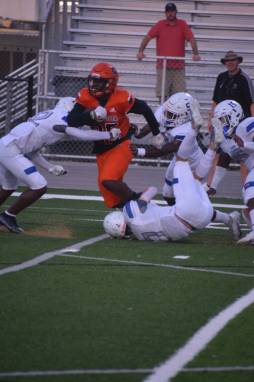 Sailors running back Jarmel Holloway fights through several Barron Collier defenders on his way to a first down.