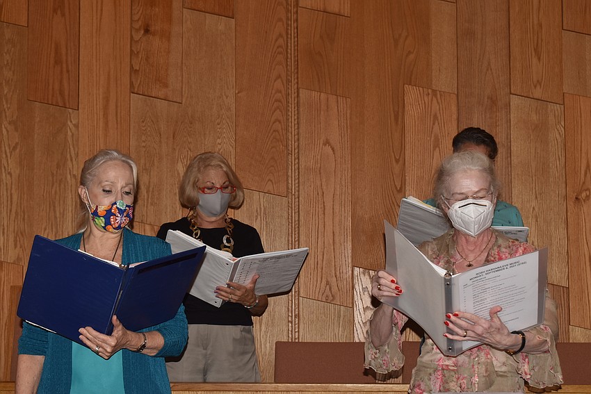 Kei Sulhi, Carole Shaw and Rebecca Taysi stand and sing.