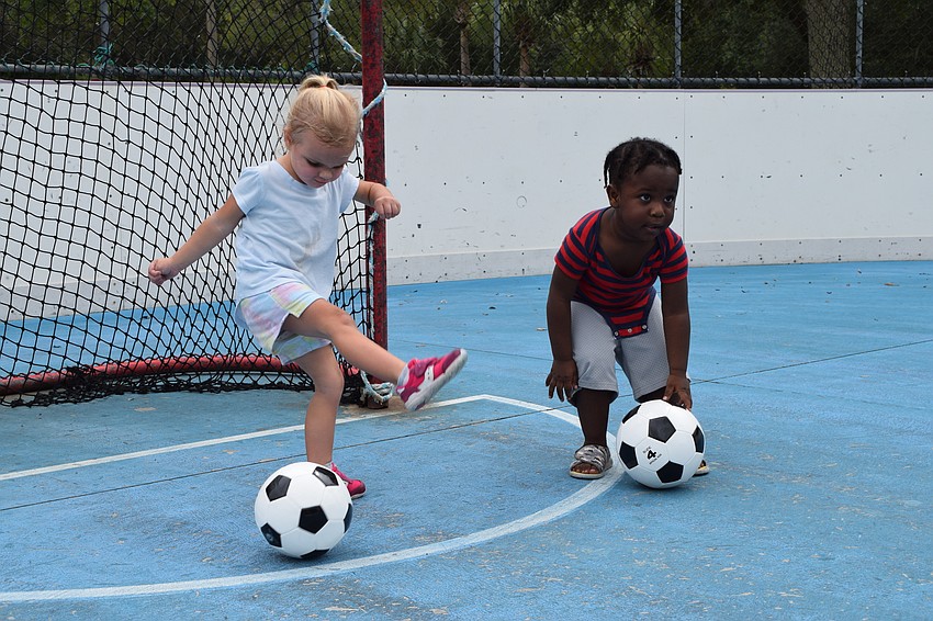 Lakewood Ranch's Kali Hill and Az Fortune, who are both 2 years old, practice kicking the ball.