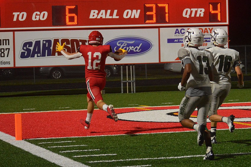 Cardinal Mooney junior Cooper Flerlage sprints away from Lakewood Ranch's Daniel D'Souza and Corey Vondran on his way to the end zone.