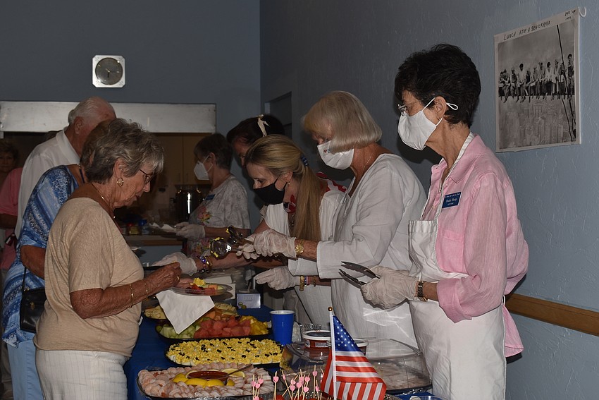 Paula Sharp starts to serve food to the waiting parishioners.