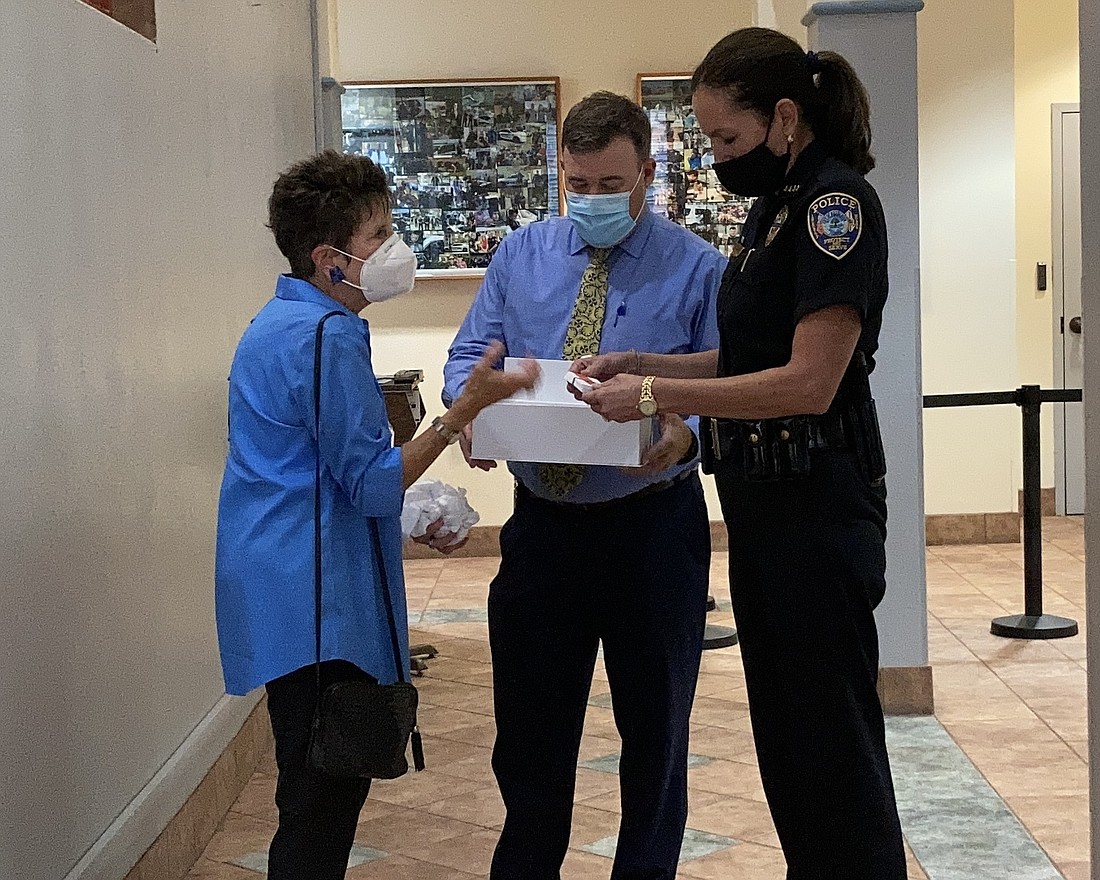 Vicki DiPaolo, the president of the University Park Women&#39;s Club, gives Josh Cramer, assistant police chief, and Melanie Bevan, the Bradenton Police chief, $5,400 worth of Publix gift cards for officers to give to people in need.