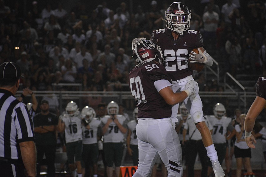 Braden River defensive lineman Cody Kawcak holds up linebacker Andrew Nordland after a Nordland interception.