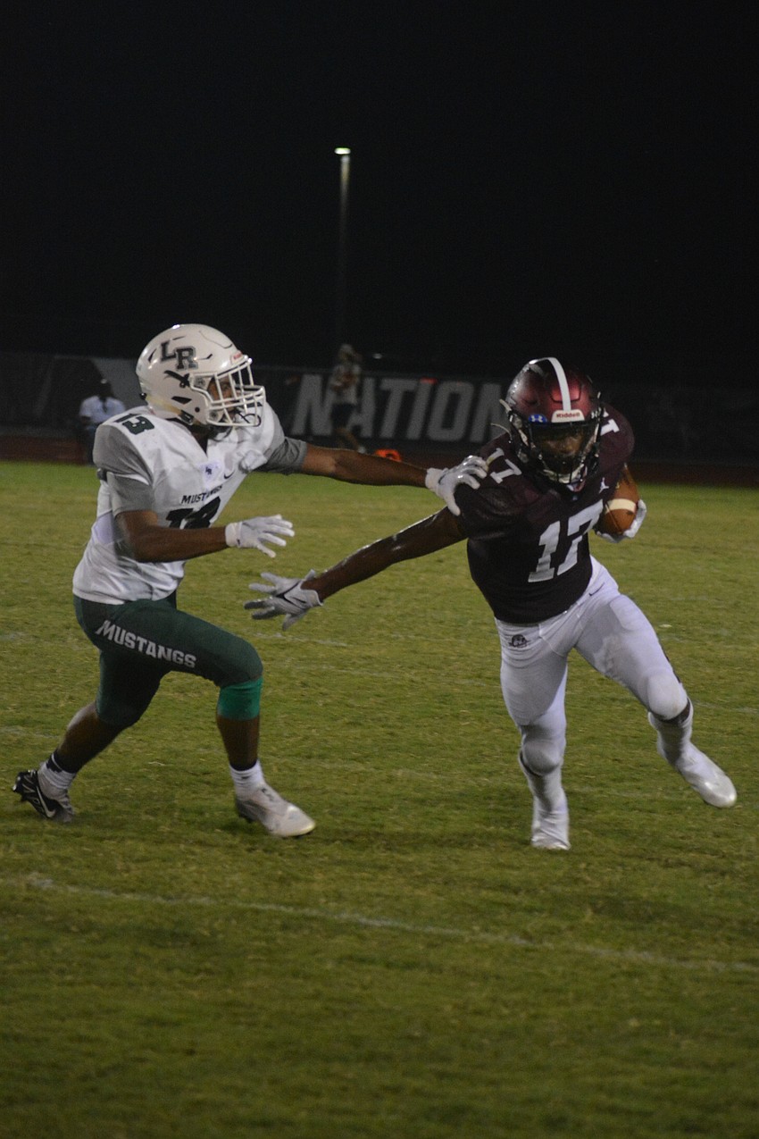 Lakewood Ranch defensive back Daniel D'Souza gets a stiff arm from Braden River wide receiver Rashawn Peterson.