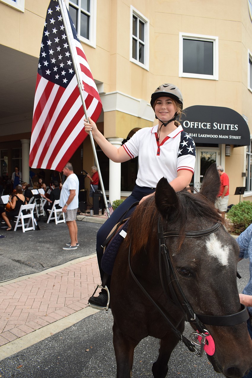 Hunter McGrath Atno, a 12-year-old Mona Jain Middle School seventh grader, presents the colors aboard Hormiga.