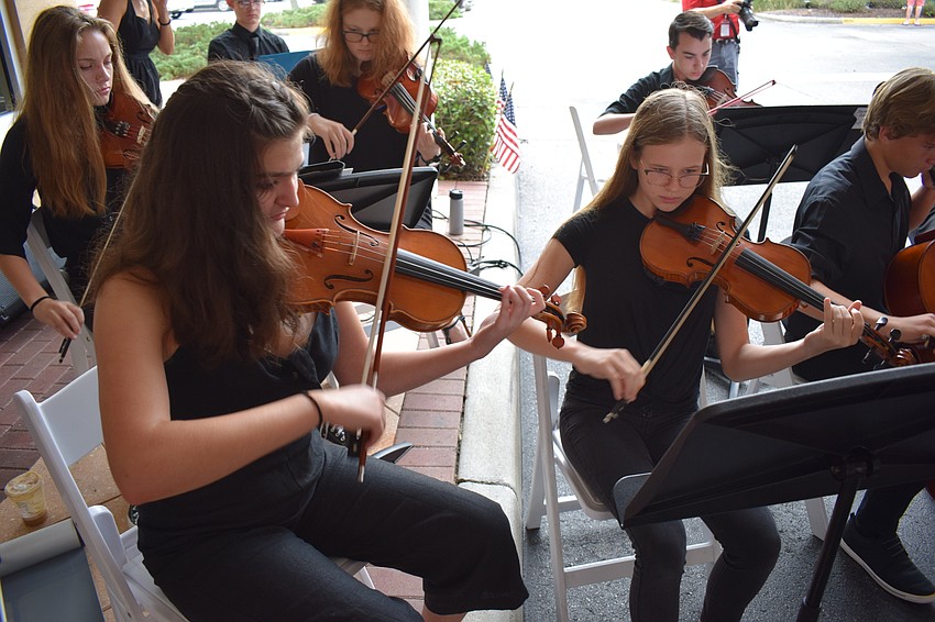 Out-of-Door Academy junior Natalie Carrion and sophomore Katy Fulton play violins during Day of Remembrance.