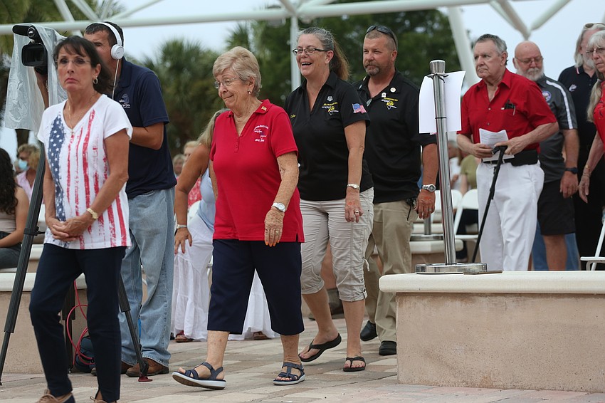 Attendees walk to the front of the plaza to receive a commemorative coin.
