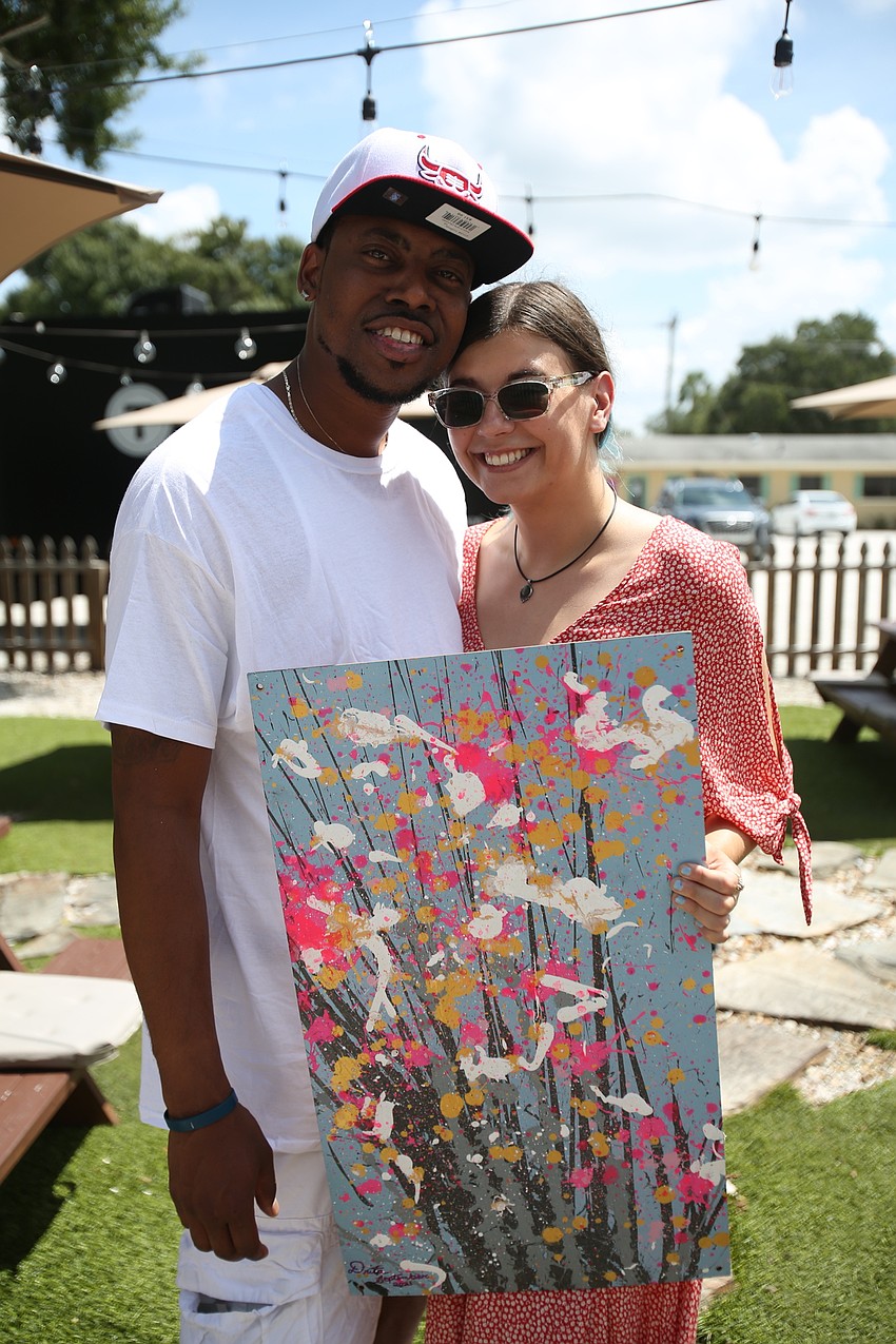 Nate Hughes and Jenna Aleen pick up art.