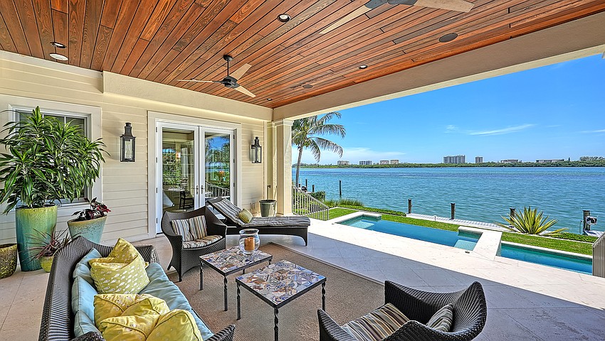 A second-floor veranda overlooks the pool deck and Sarasota Bay.