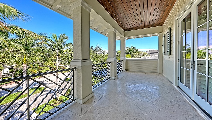 A second-floor veranda overlooks the pool deck and Sarasota Bay.
