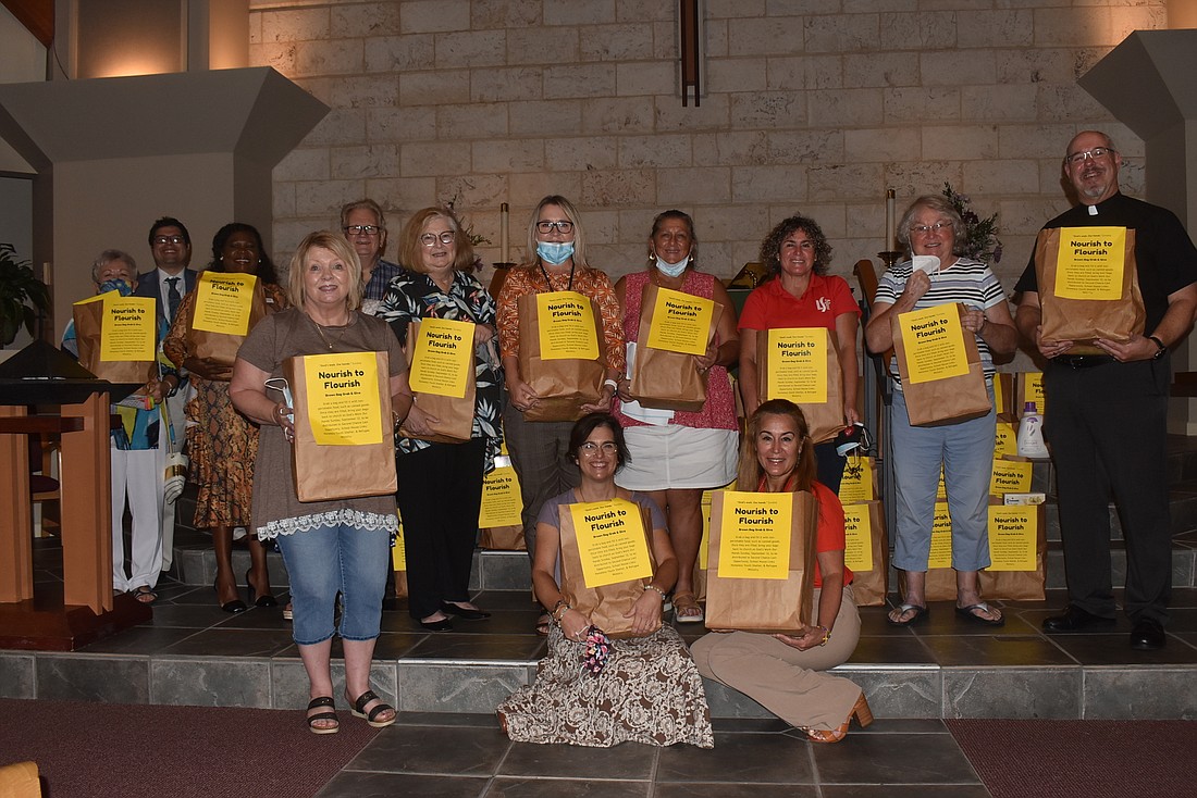 Leaders from the service organizations posed with bags of food.