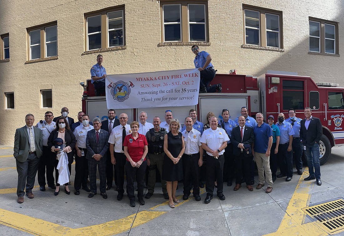 Myakka Fire Protection District and East Manatee Fire Rescue District firefighters gather with Manatee County Commissioners to celebrate the merger of the two departments. Photo by Scott Lockwood.
