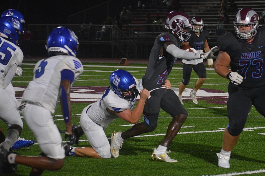 Rams senior wideout Jaron Glover (4) fights through a Sebring tackle.