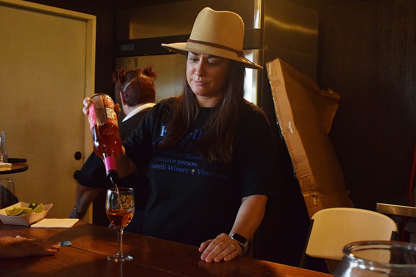 Kristin Hokanson, the owner of FioRelli Winery and Vineyard pours a glass of wine for a guest.