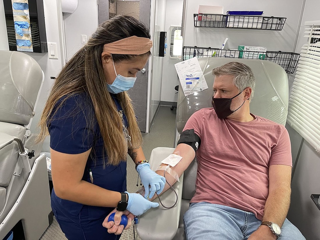 SunCoast Blood Center&#39;s Diana Vitale prepares John Butzko, with Grapevine Communications, so he can donate blood.
