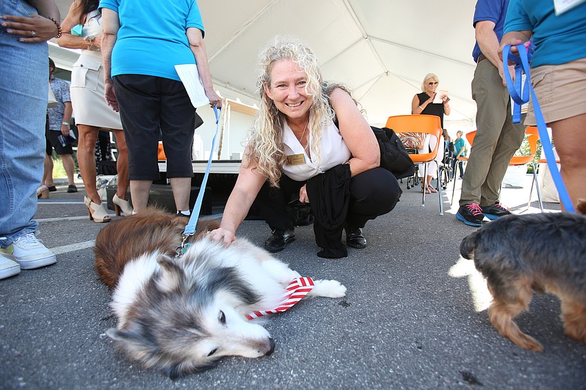 Commissioner Jen Ahearn-Koch pets Sparrow the dog.