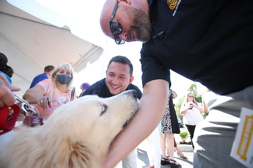 Austin York and Anthony Herzog play with Lance the dog.