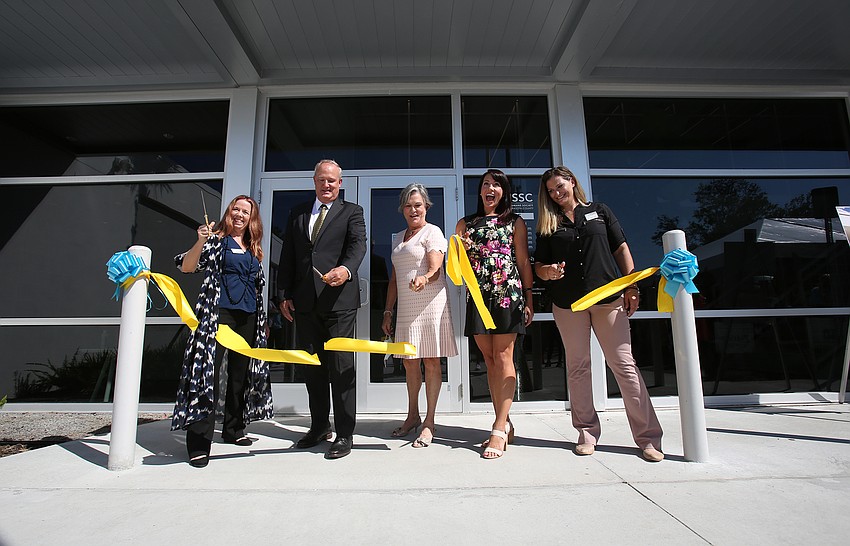 Executive Director Anna Gonce, John Raleigh, Teresa Jones, Jen Steube and Rebecca Gustafson cut the ribbon.