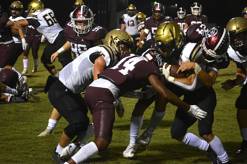 Pirates sophomore Jamarie Rutledge (14) lays a hit on the Hornets' Riley Willis.
