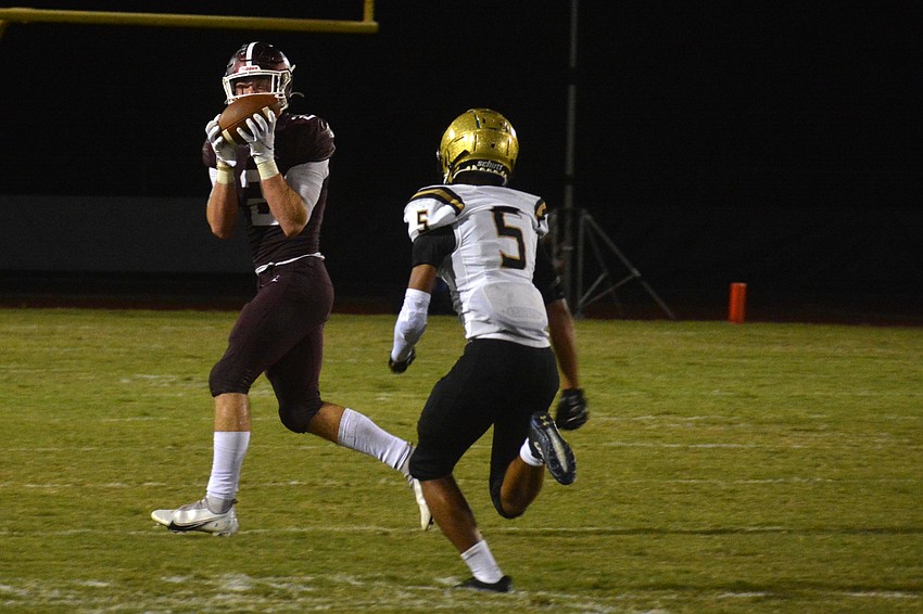 Pirates senior Evan Dangler catches a pass from senior Bryan Kearse over the head of Hornets junior Mark Nonsant.