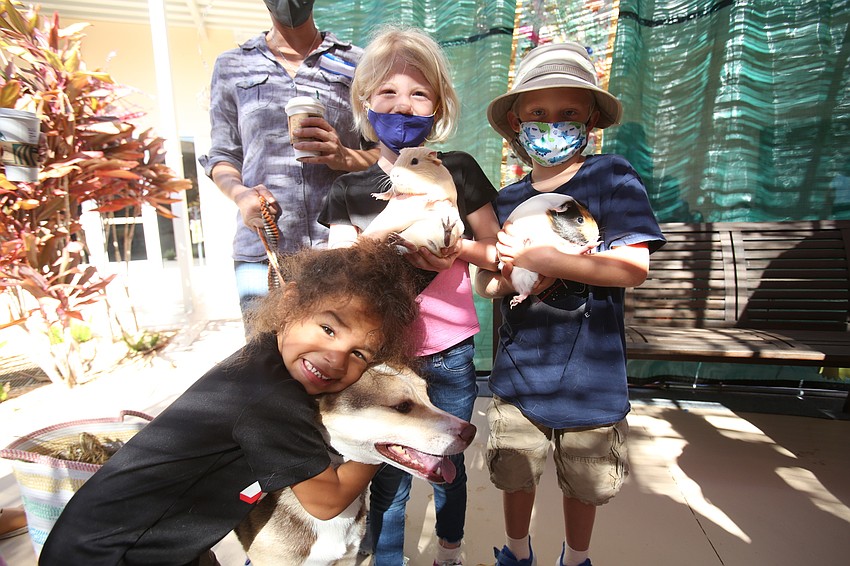 Naiah, Victoria and Max Dumbaugh hold Zoe the dog and Lady and Lovie the guinea pigs.