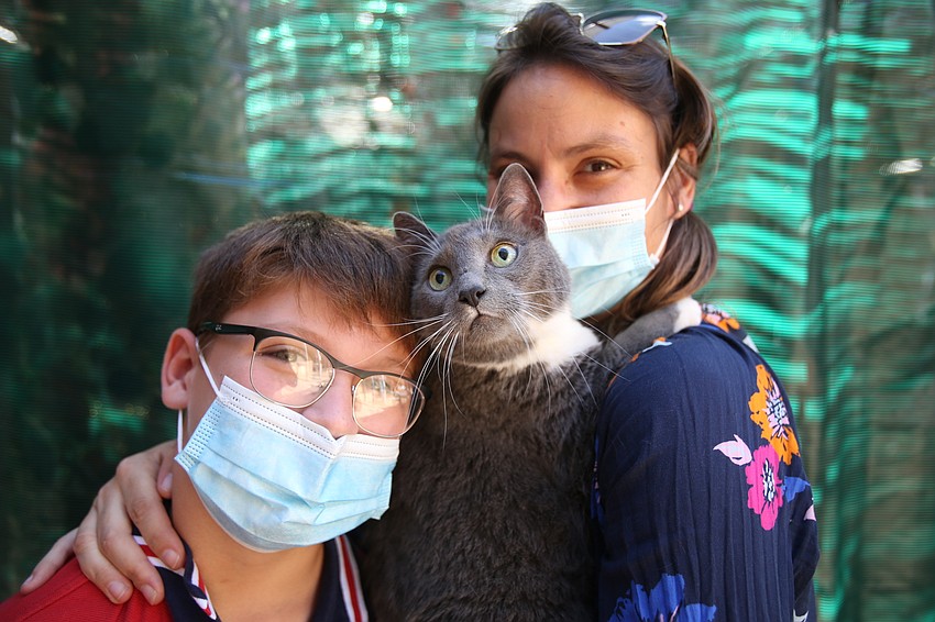 Caleb and Tara McCaffrey hold up Elijah the Me/Mop cat.