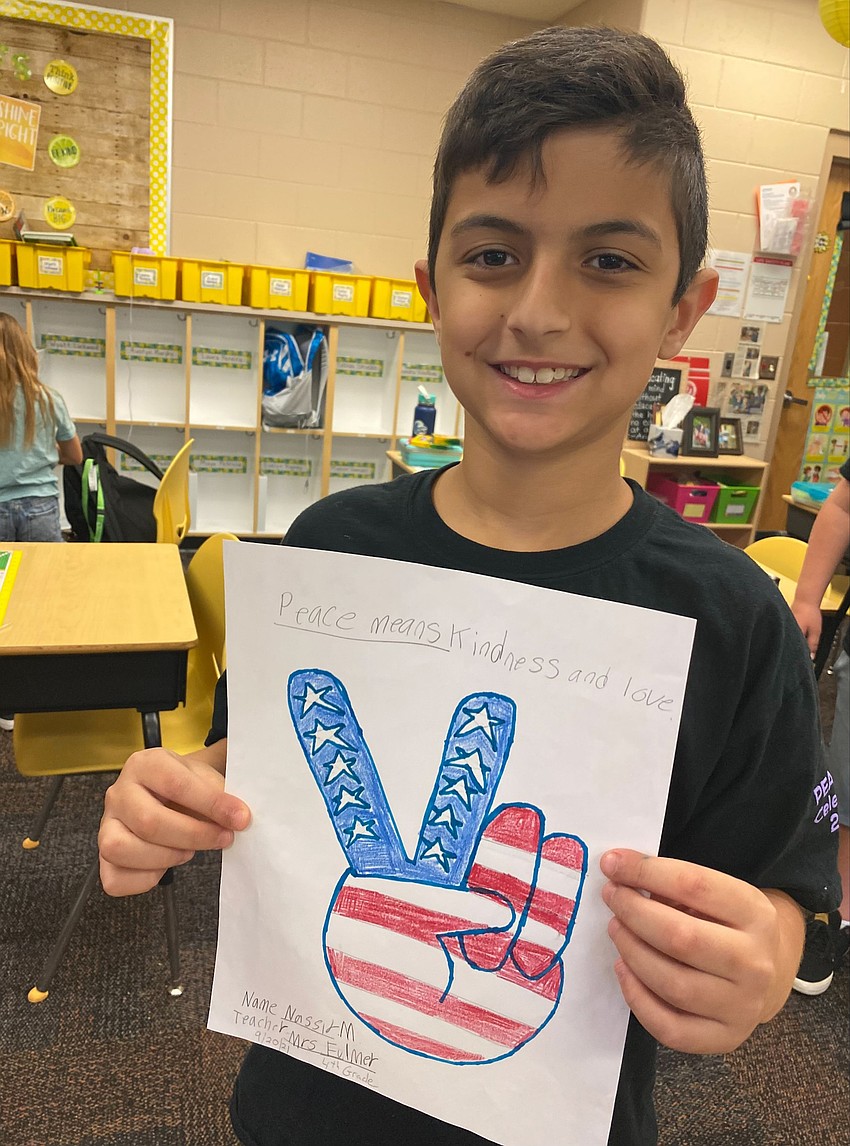 Fourth grader Nassir Matta shows off his Peace Day artwork. Matta wrote 
