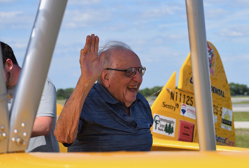 Chip Tominelli, who is a Cypress Springs Gracious Retirement Living resident and World War II veteran, waves to his fellow residents and veterans after landing. 