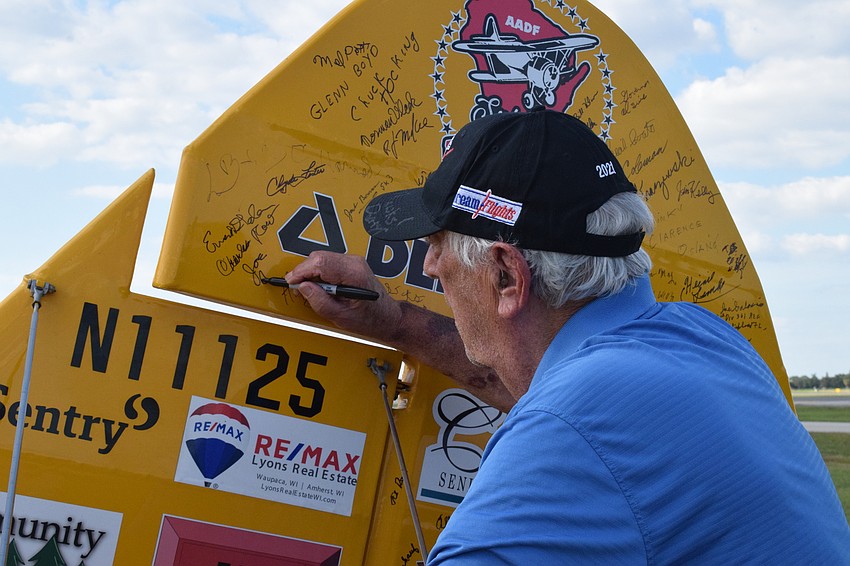 Joe Abrams, a Cypress Springs Gracious Retirement Living resident and Korean War veteran, signs the Spirit of Wisconsin.