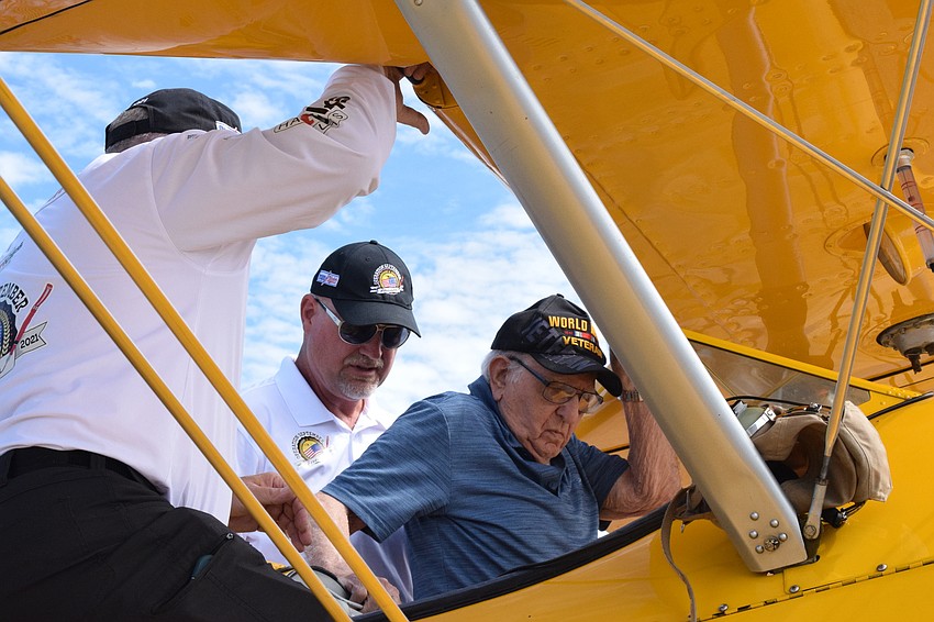 John Swan and Darryl Fisher with Dream Flights helps Chip Tominelli, a World War II veteran who turns 100 on Oct. 8 get into the plane.