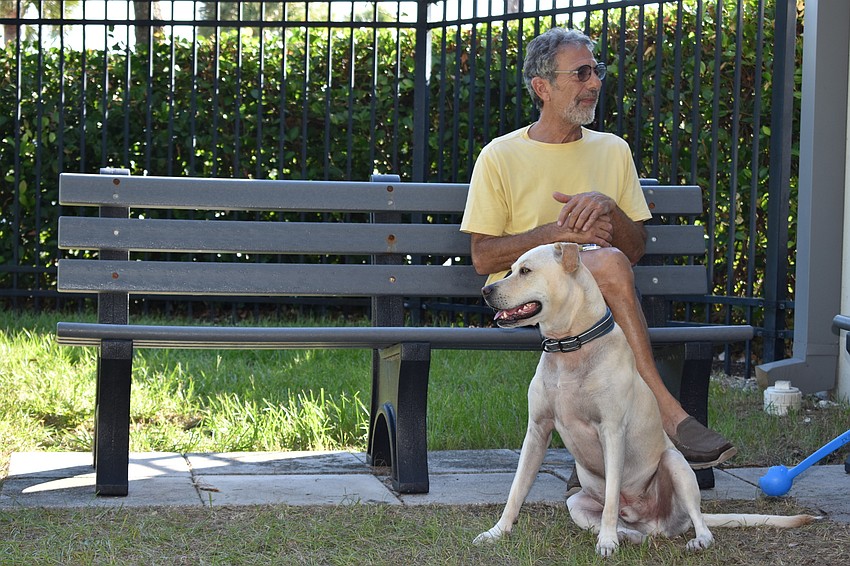 Conrad Panza and his dog Oliver sit on Friday morning at Bayfront Park's dog park.