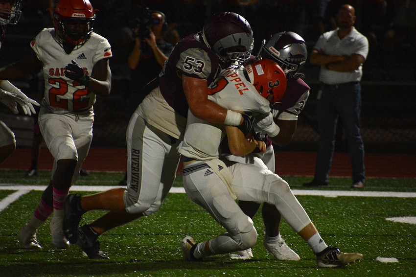 Sarasota quarterback Lance Trippel is sacked by the Rams defense.