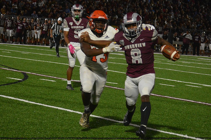 Riverview running back Jay'den Birch fends off Sarasota's Kafale Rivers.