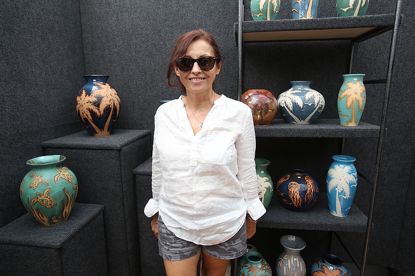 Christina Williams paints the pottery items sold by her and her husband, Don Williams, with DMW Fine Arts.