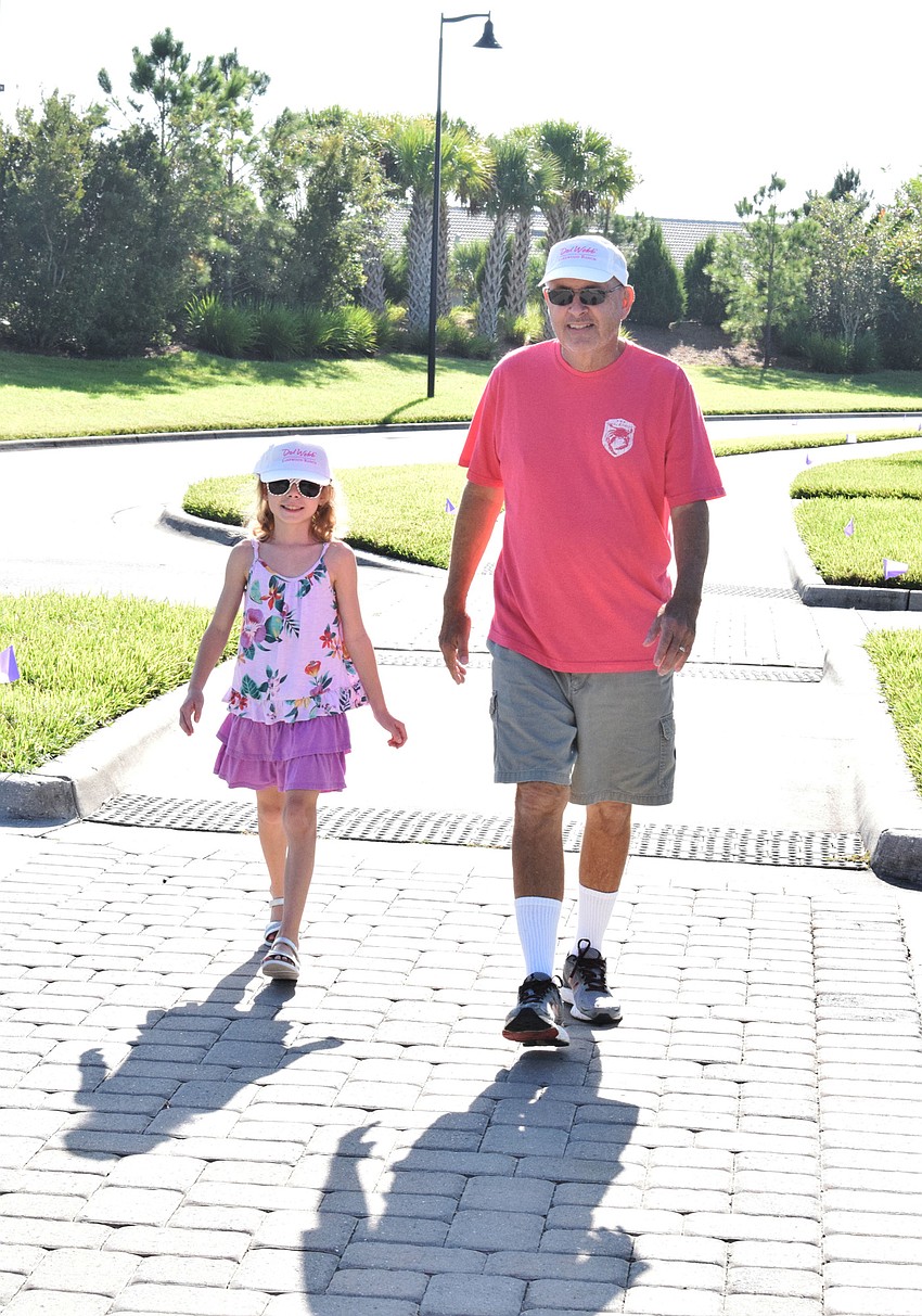 Annabelle Duryea, who is 9 years old, walks with her grandfather, Rob Pavlat, who is a Del Webb resident.