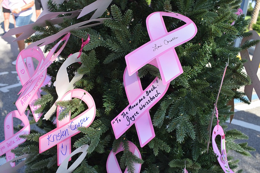 Participants put a pink ribbons on a tree to honor people who have been touched by breast cancer.