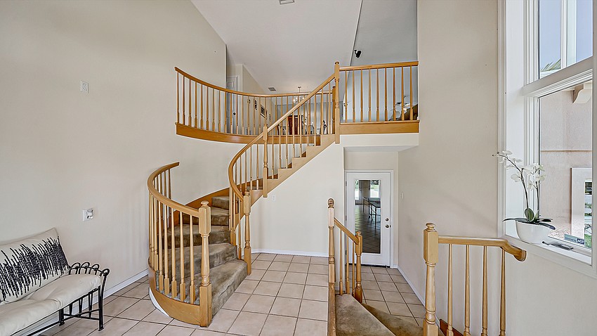 Double doors open to the foyer entry and a winding staircase.