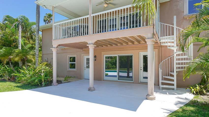 A back terrace overlooks the pool and tropical landscaping.