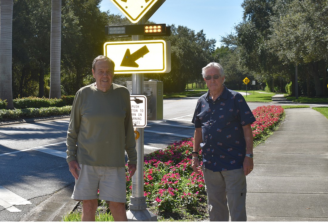 Peyton Philips (left) and Darby Connor stand at one of the lighted pedestrian signs at Tara Boulevard and Tara Preserve. The signs were installed in 2020 in an effort to help improve safety on Tara Boulevard.