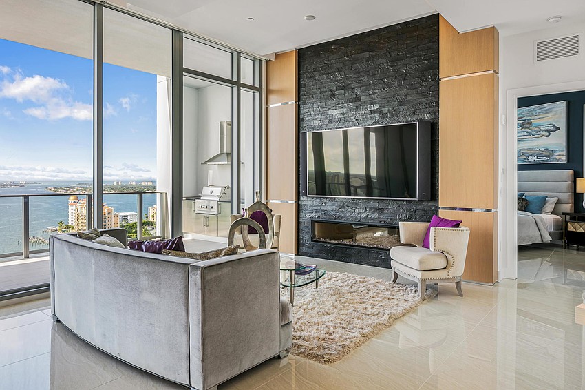 A 12-foot high wall of impact glass framing the open-concept living and dining room.