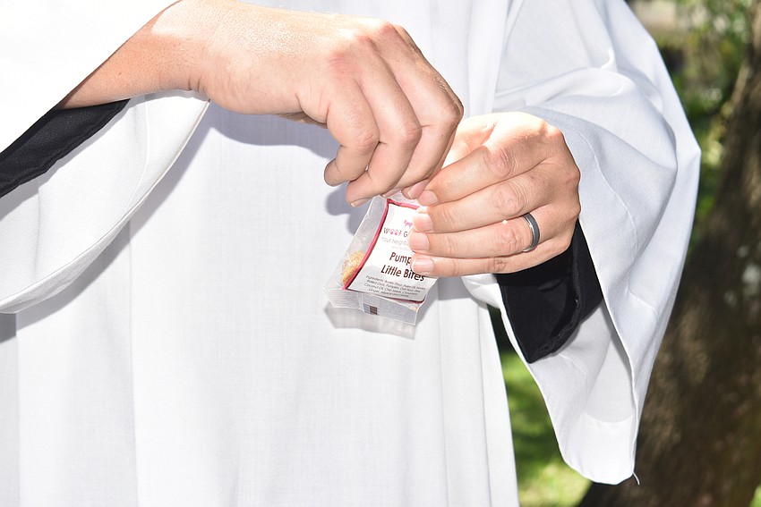 Father Dave Marshall opens a pack of dog biscuits.