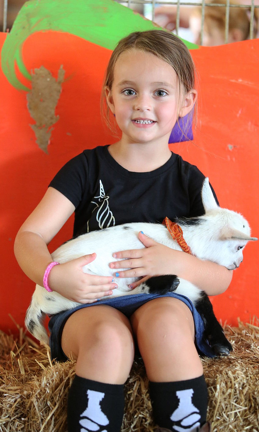 Brooklyn Brenner plays with a young goat.