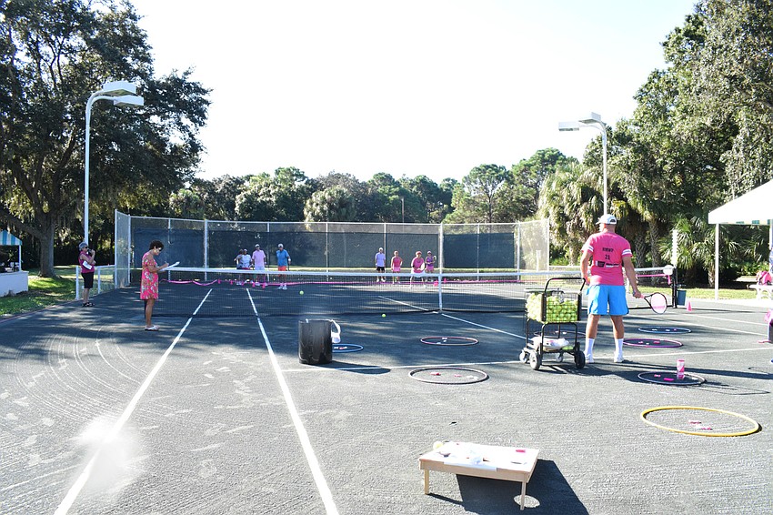 Tennis competition participants try to land a tennis ball in a hula hoop, bin or on a cornhole board to earn points and prizes.