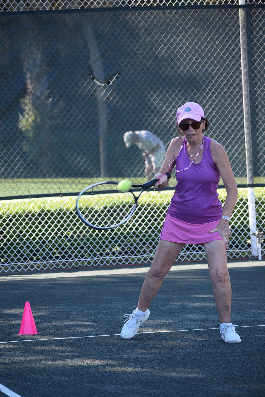 Rose Waag hits the ball to try to have it land in a hula hoop, bin or cornhole board so she can earn points in the tennis skills match.