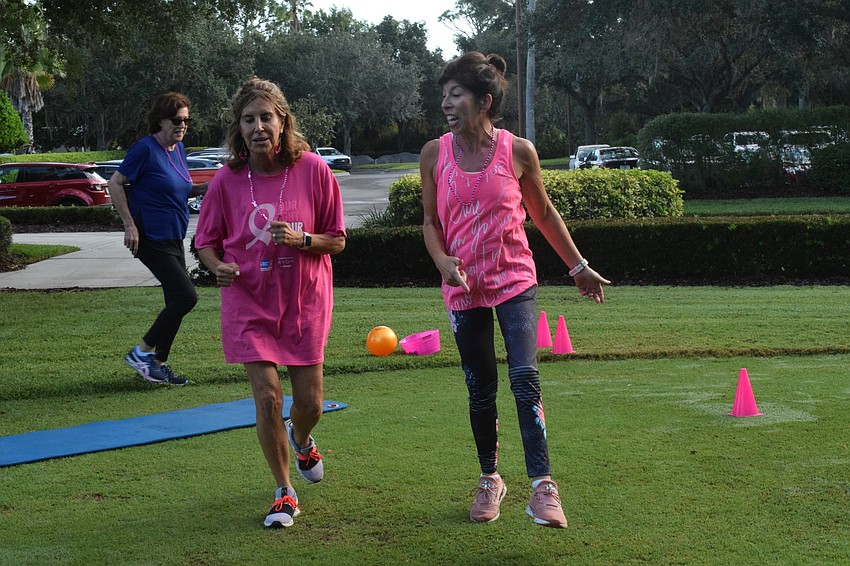 Gail Snyer and Gwen Murphy run alongside each other during musical squats.